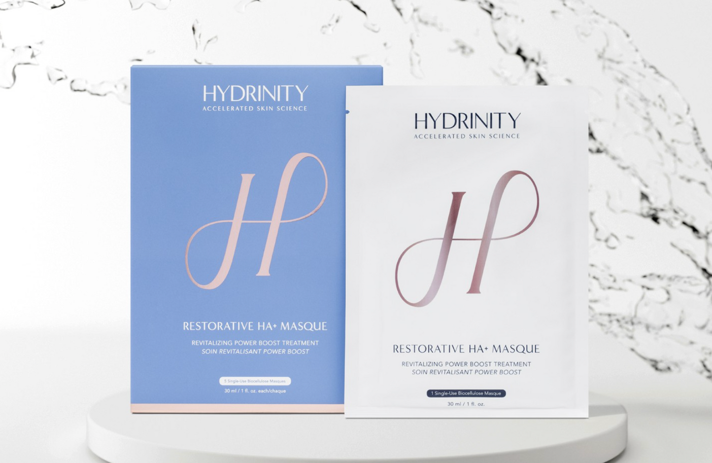 Two Hydrinity Restorative HA+ Masque packages on a white background with decorative elements.