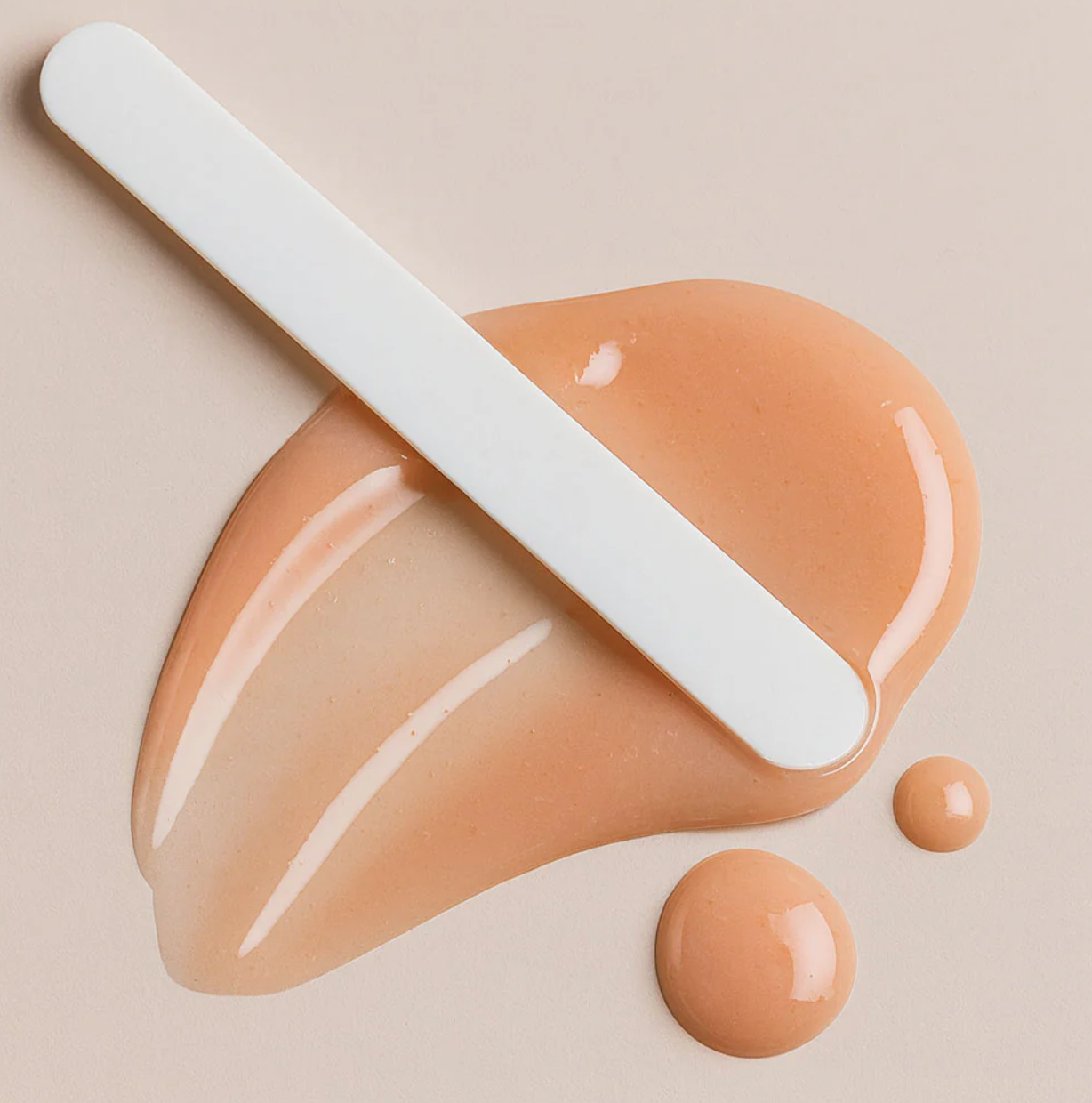 Beige foundation with a spatula on a beige background