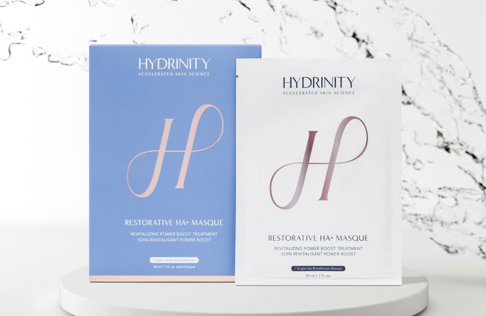 Two Hydrinity Restorative HA+ Masque packages on a white background with decorative elements.