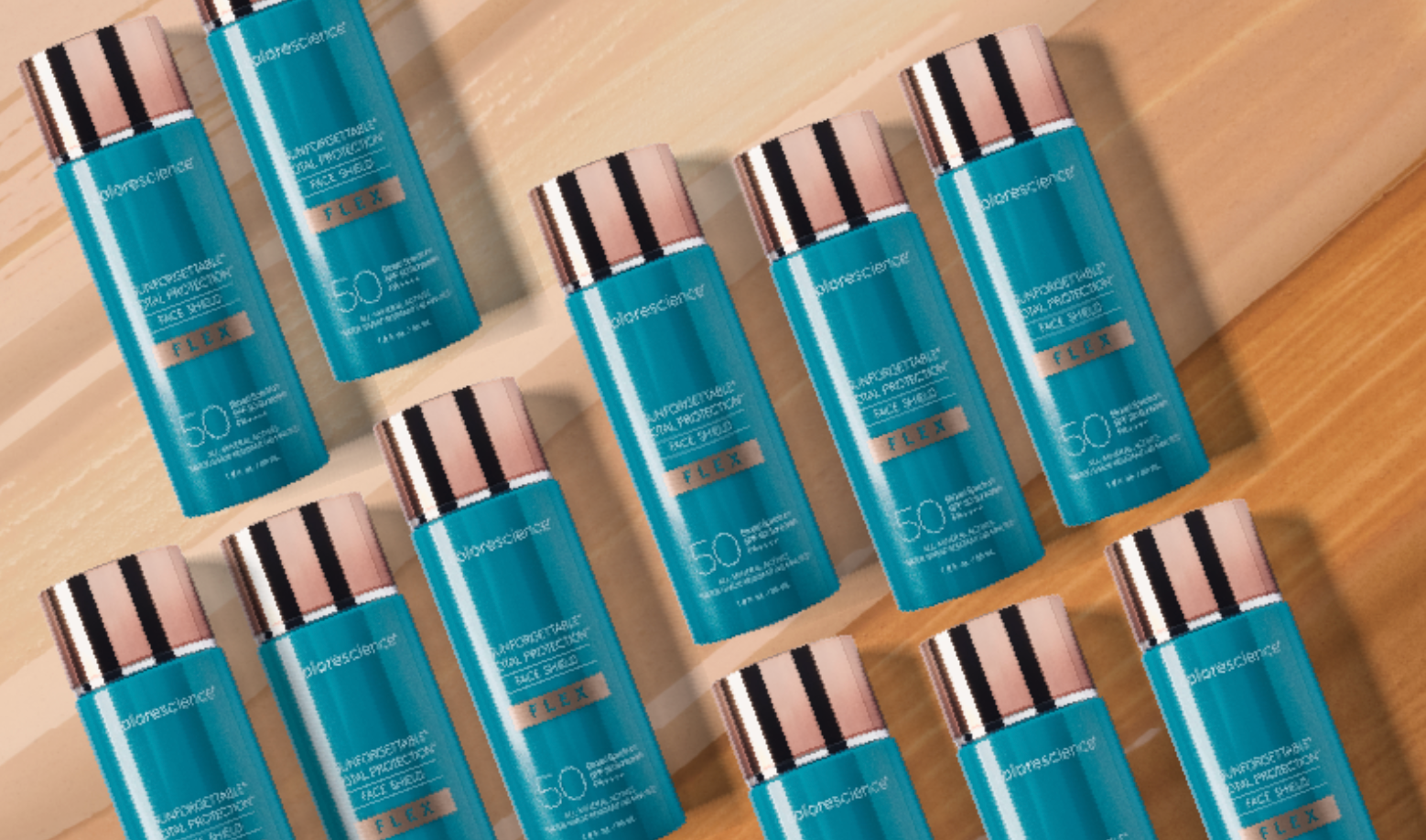 Multiple blue skincare bottles with rose gold caps on a wooden surface