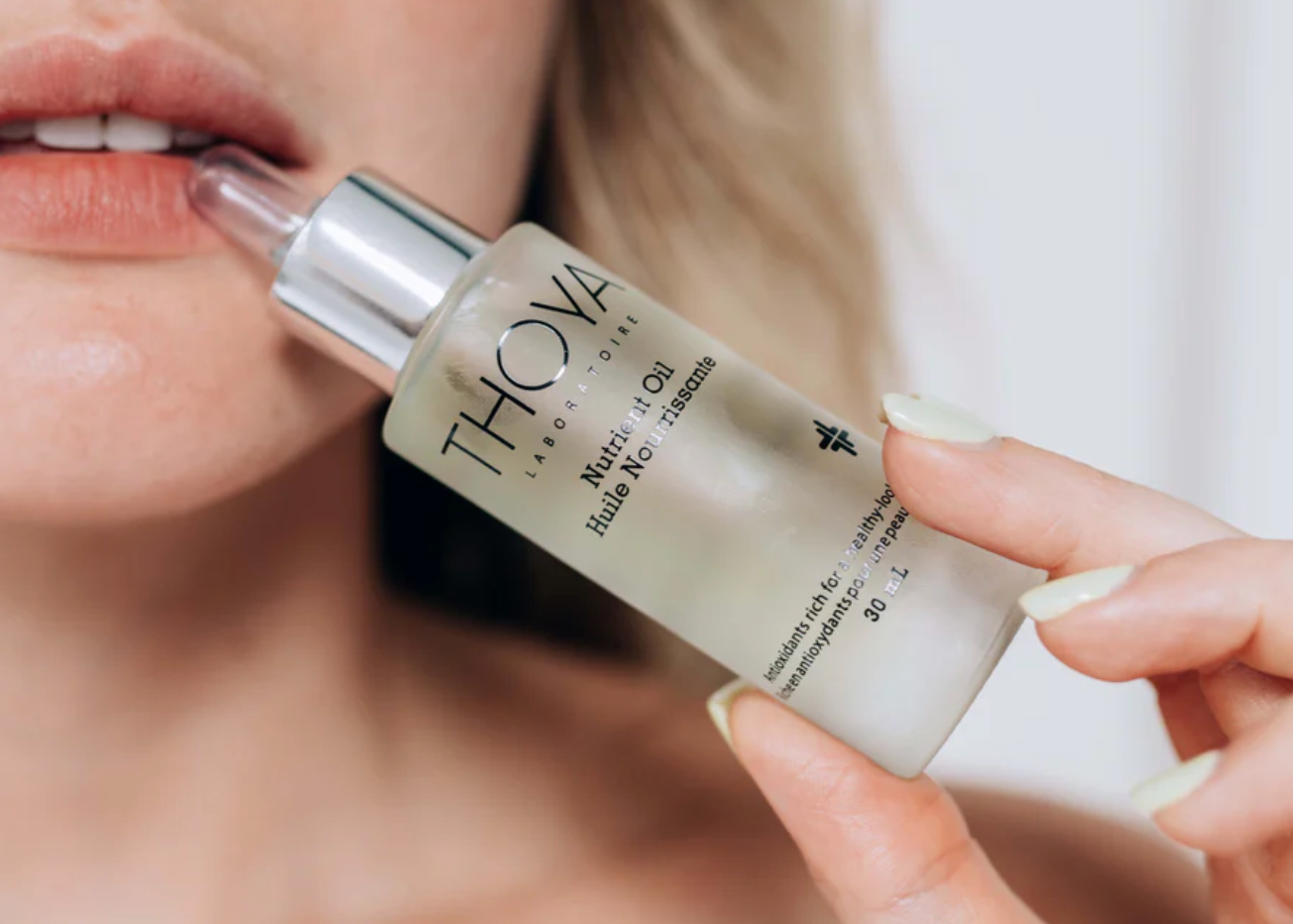 Person applying a THOYA skincare product to their lips.