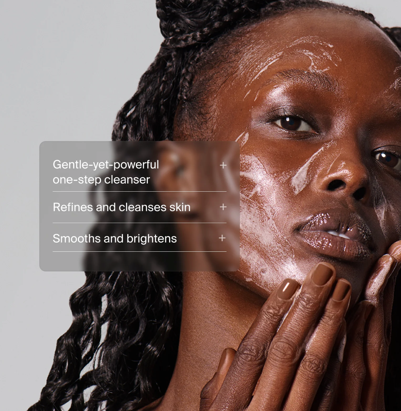 Woman applying a skincare product with text about a cleanser on a gray background
